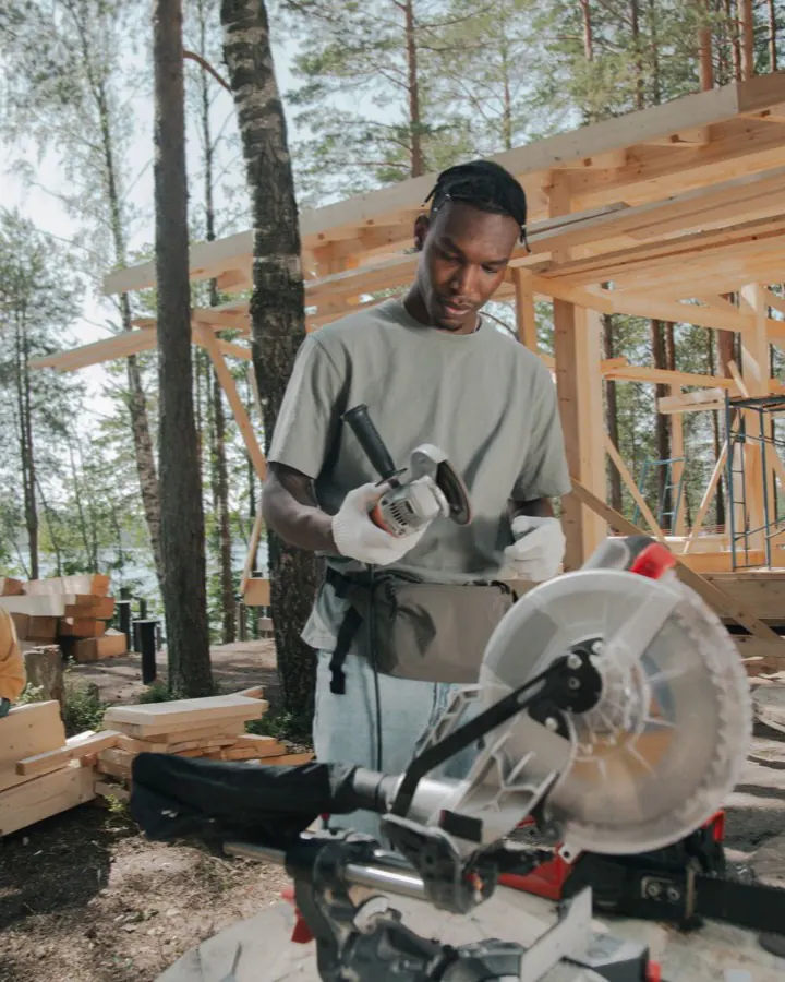 Une équipe de construction consulte une tablette sur un chantier, casques sur la tête.